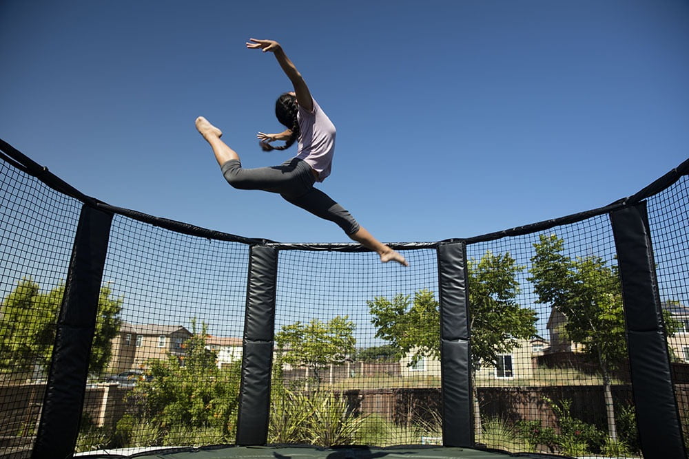 child doin aerobatics on her trampoline