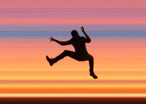 silhouette of a person jumping on a trampoline
