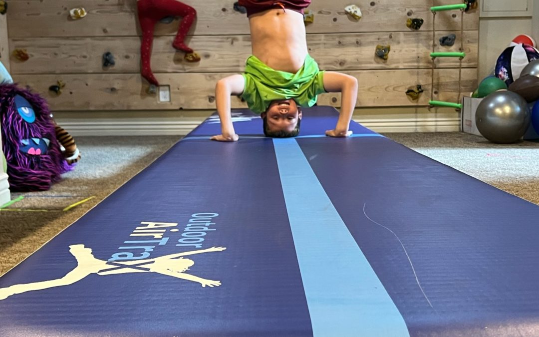 man does head stand on Outdoor Air track