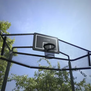 A net around a round trampoline with a basketball hoop.